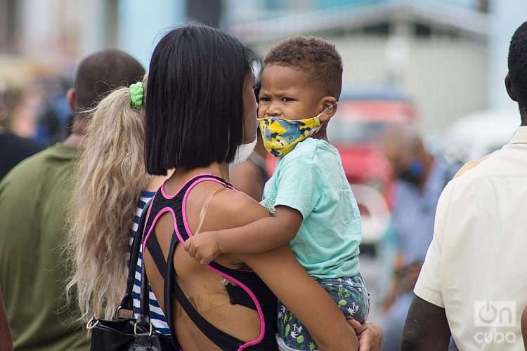 Una madre con su hijo en La Habana, el martes 31 de mayo de 2022, tras la eliminación del uso obligatorio de la mascarilla por las autoridades cubanas. Foto: Otmaro Rodríguez.