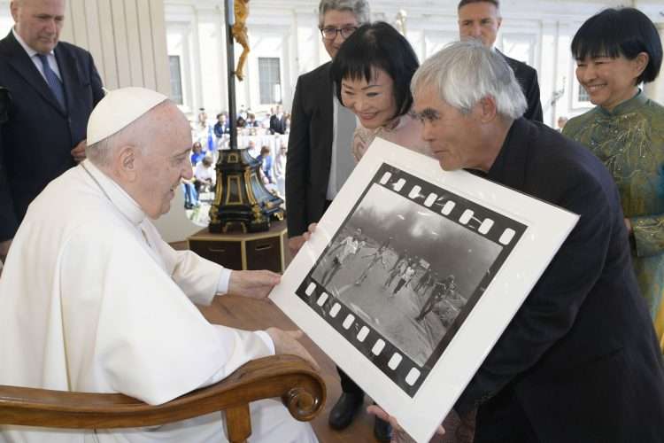 Kim Phuc (c), conocida como "la niña del napalm" y Nick Ut (d), el fotógrafo retirado de la agencia AP, entregan al papa Francisco una copia de la icónica foto tomada un 8 de junio de 1972 en plena guerra de Vietnam. Foto: Vatican Media/Efe.