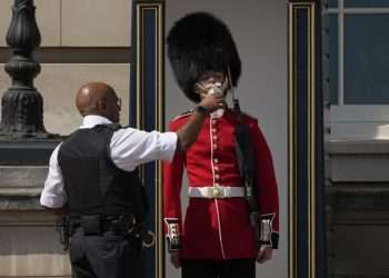Un policía británico refresca a un miembro de la Guardia Real. Foto: Yahoo.