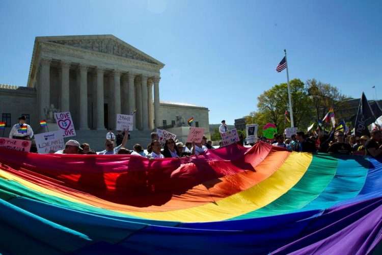 Manifestantes con una bandera del arcoiris ante la Corte Suprema de Washington el 28 de abril de 2015, cuando se deliberaba sobre el matrimonio entre personas del mismo sexo en el caso Obergefell v. Hodges. Foto: AP.