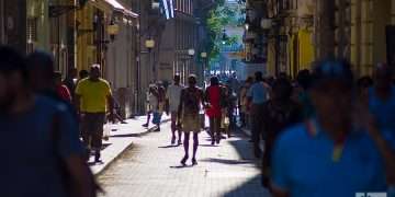 Personas caminan bajo el sol en la calle Obispo, en La Habana. Foto: Otmaro Rodríguez.