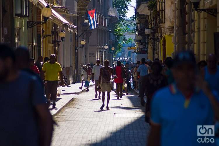 Personas caminan bajo el sol en la calle Obispo, en La Habana. Foto: Otmaro Rodríguez.