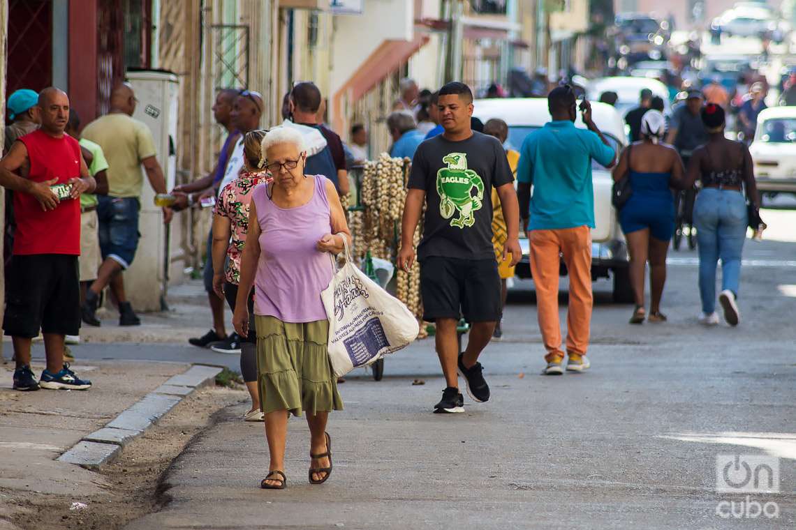 Personas caminan bajo el sol en una calle de La Habana, en sus actividades cotidianas. Foto: Otmaro Rodríguez.