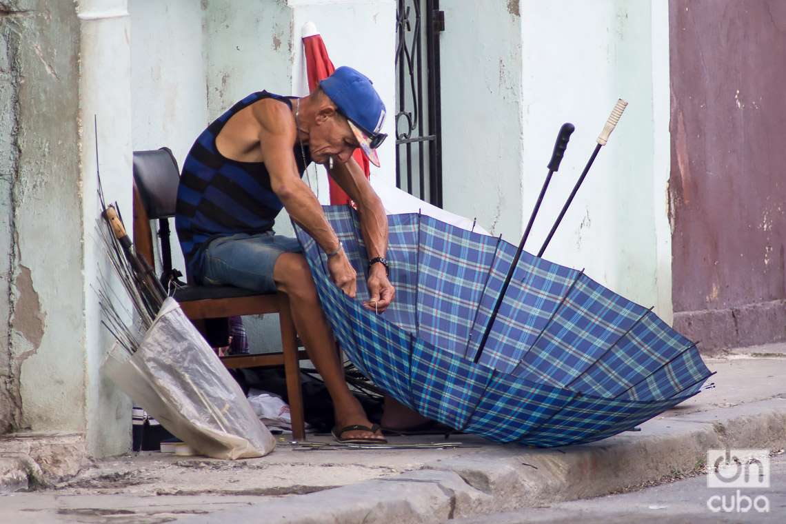 Un reparador de sombrillas en una calle de La Habana. Foto: Otmaro Rodríguez.