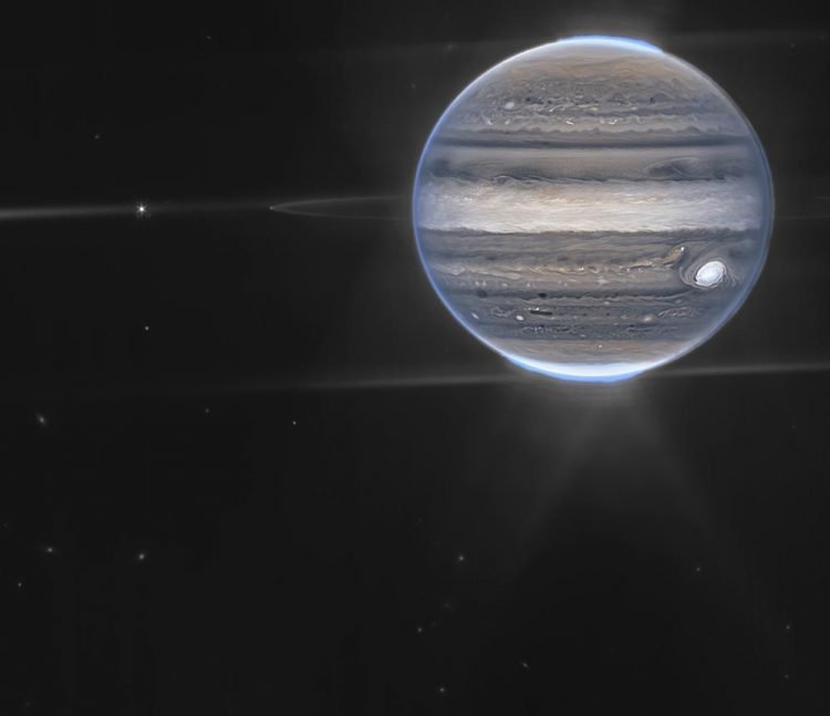 Imagen obtenida por el telescopio espacial James Webb. Los anillos del planeta y algunos de sus pequeños satélites son visibles junto con las galaxias de fondo. Foto: NASA vía AP.