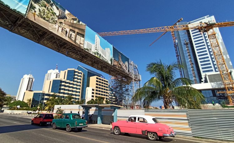 Autos pasan junto a hoteles en construcción y otros ya abiertos, en La Habana, en agosto de 2022. Foto: Ernesto Mastrascusa / EFE.