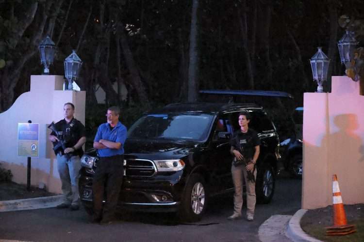 Agentes del FBI guardan la puerta principal de Mar-a-Lago el lunes mientras dura el allanamiento. | Foto:  AP