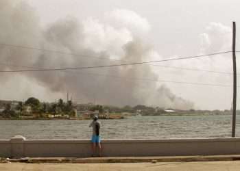 Hombre observa el humo del incendio en Base de Supertanqueros, Matanzas, martes 9 de agosto. Foto: Sergio Martínez.