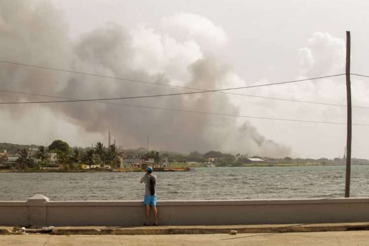 Hombre observa el humo del incendio en Base de Supertanqueros, Matanzas, martes 9 de agosto. Foto: Sergio Martínez.