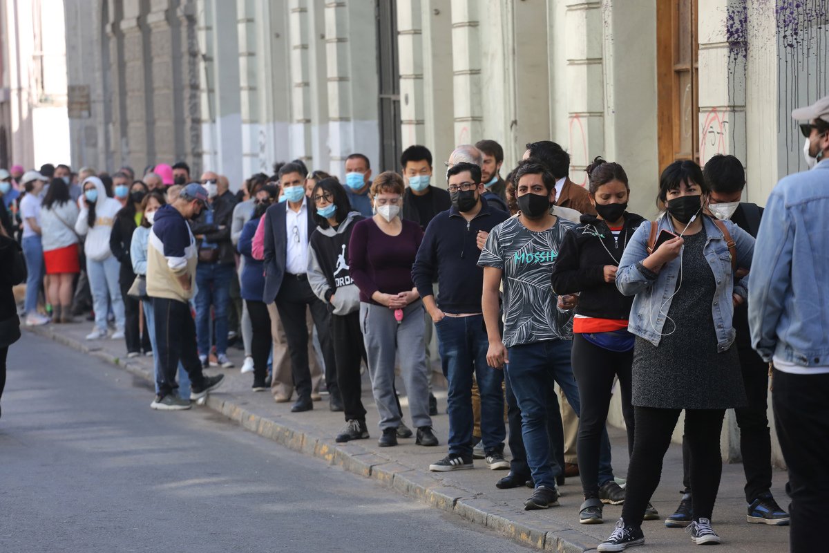 Ciudadanos hacen fila para votar el plebiscito constitucional de este domingo en Santiago de Chile. Foto: Elvis González / EFE.