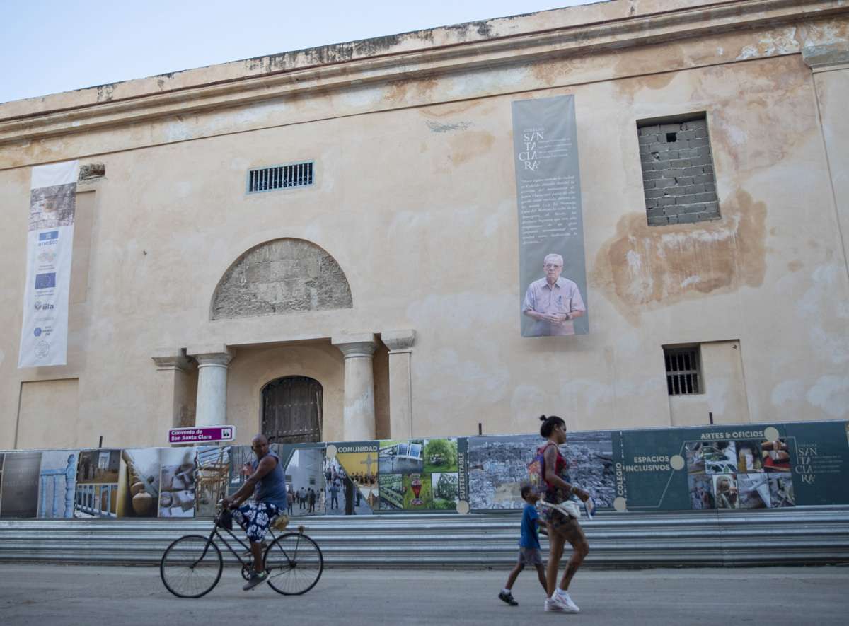 Personas pasan frente al antiguo Convento de Santa Clara, en La Habana, el cual atraviesa una profunda restauración para reconvertirlo en escuela de arte. Foto: Yander Zamora / EFE.
