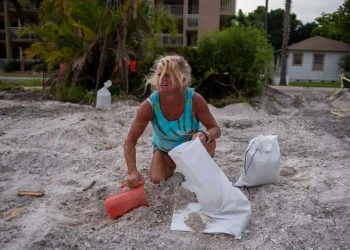 Una mujer llena sacos de arena en preparación para el huracán Ian en St. Pete Beach el 26 de septiembre de 2022.  Foto: Tampa Bay Times.