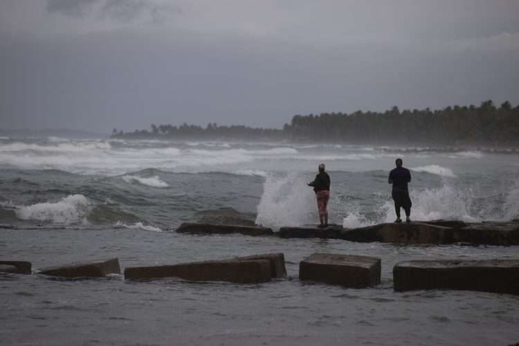 Dos personas pescan en la playa mientras República Dominicana se preparaba para el paso del huracán Fiona. Foto: Orlando Barría/Efe/Archivo.