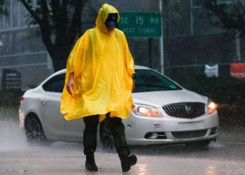 Un hombre camina bajo la lluvia, en Brickell, el centro de Miami. Foto: The Miami Herald.