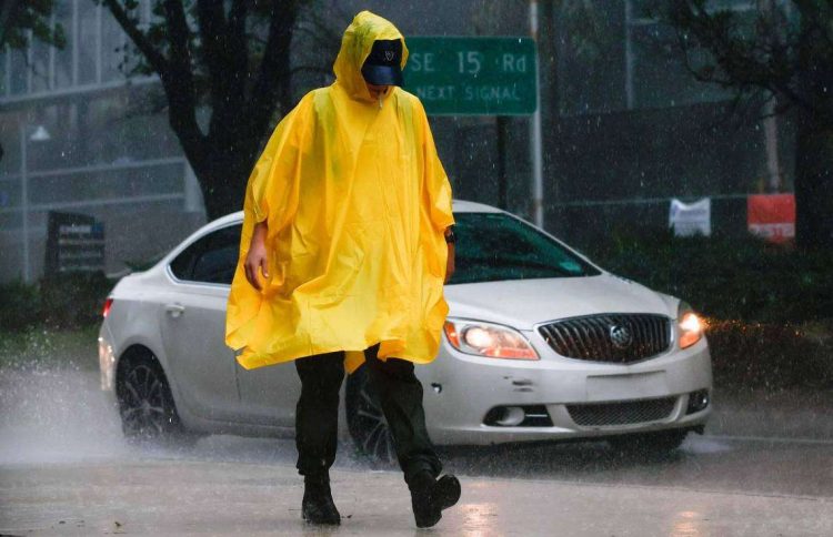Un hombre camina bajo la lluvia, en Brickell, el centro de Miami. Foto: The Miami Herald.