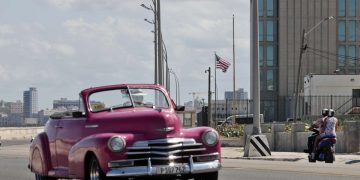 Un automóvil clásico pasa frente a la embajada de Estados unidos en La Habana. Foto: Ernesto Mastrascusa / EFE.