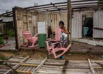 Una mujer intenta recuperar sus pertenencias de lo que queda de su casa tras el paso del huracán Ian. Foto: AP.