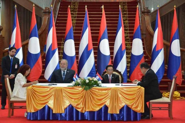 El primer ministro cubano Marrero Cruz (3-i) y su homólogo de Laos, Phankham Viphavanc (2-d), presencian la firma de acuerdos entre representantes de ambos países, durante la visita de Marrero y otros funcionarios cubanos al país asiático. Foto: Prensa Latina.