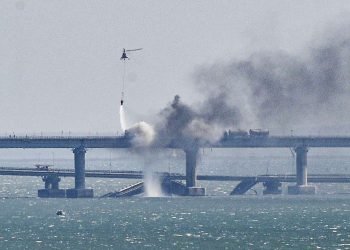 Un helicóptero arroja agua sobre el incendio provocado por una fuerte explosión en el puente que une la península de Crimea con Rusia. Foto: Stringer / EFE.