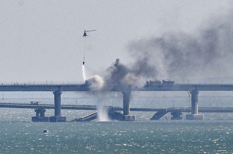 Un helicóptero arroja agua sobre el incendio provocado por una fuerte explosión en el puente que une la península de Crimea con Rusia. Foto: Stringer / EFE.