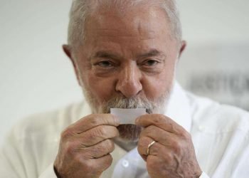 Lula da Silva besa el recibo electoral tras votar. | Foto: Andre Penner / AP