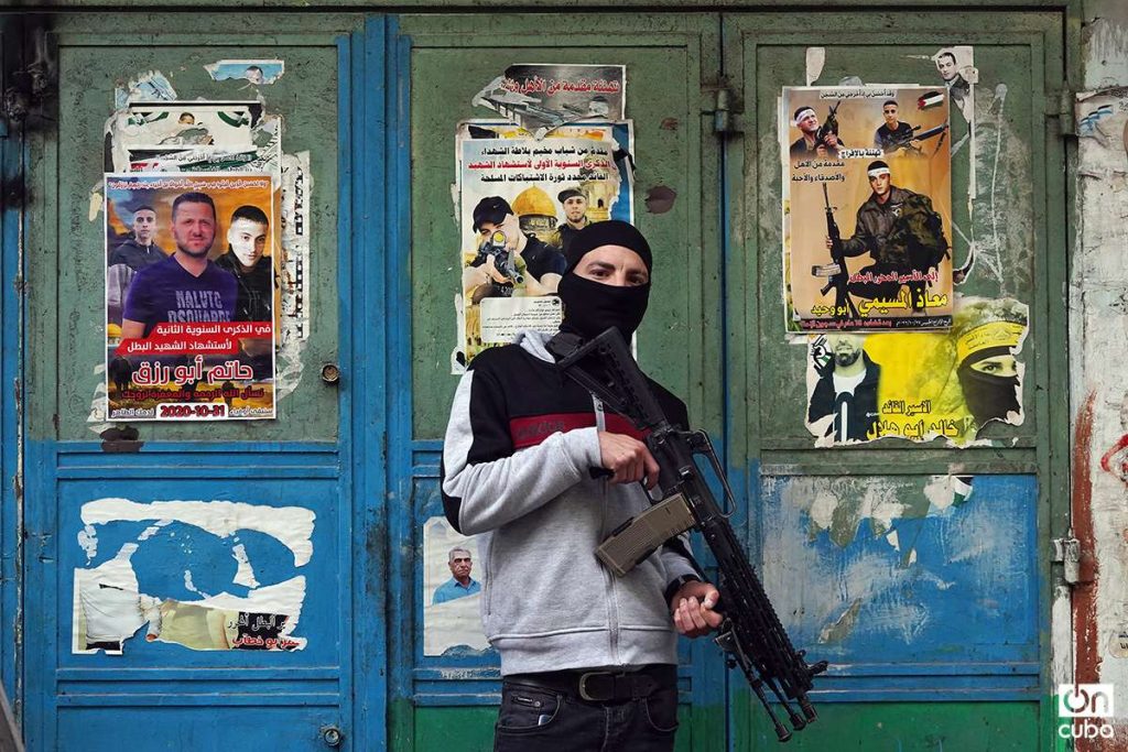 Un miliciano de la Brigada Balata posa junto a carteles con imágenes de otros combatienetes fallecidos. Considerados mártires por los palestinos y terroristas por Israel.