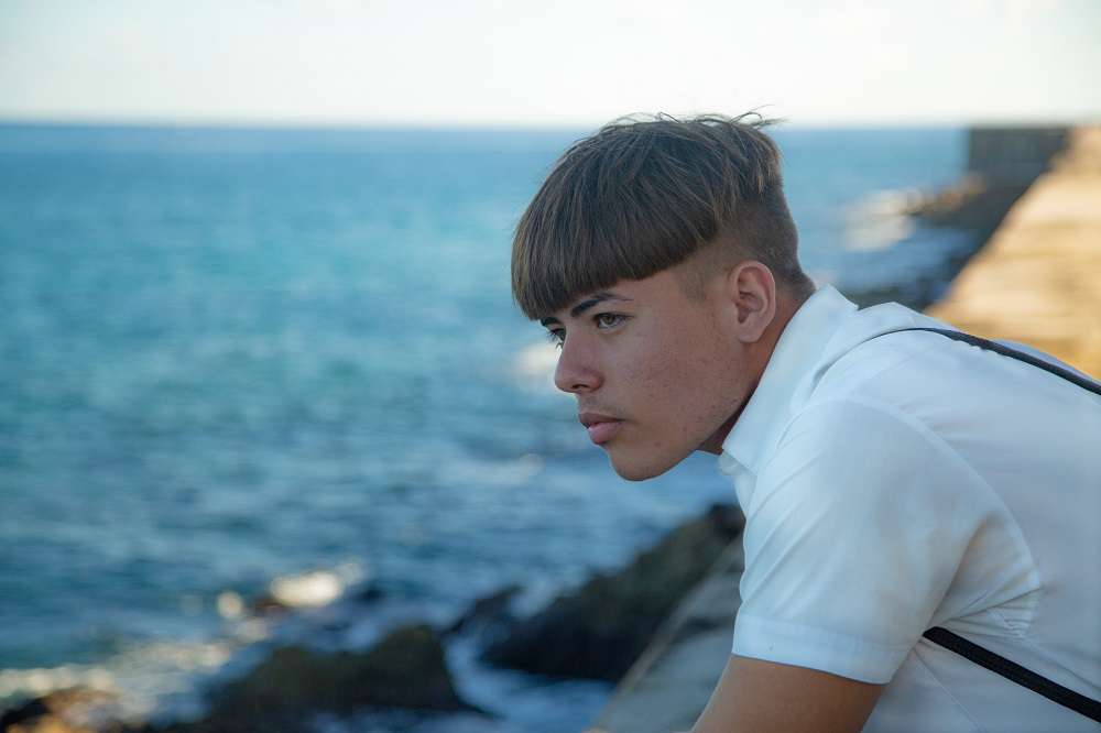 adolescente muchacho mira al mar en el malecon de la habana foto jorge ricardo