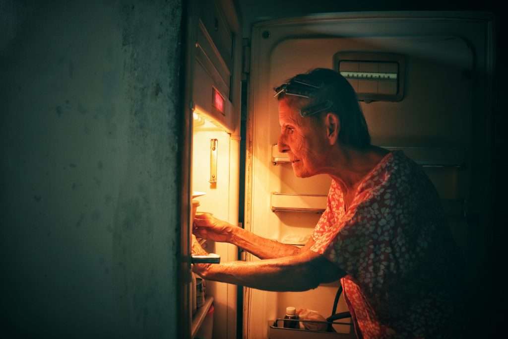 Anciana mira su refrigerador en Cienfuegos Cuba 2022 de la serie Escenas Domésticas de Franko