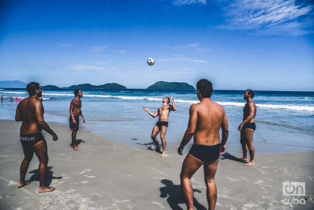 group of friends play soccer on a beach in Sao Pablo, Brazil.