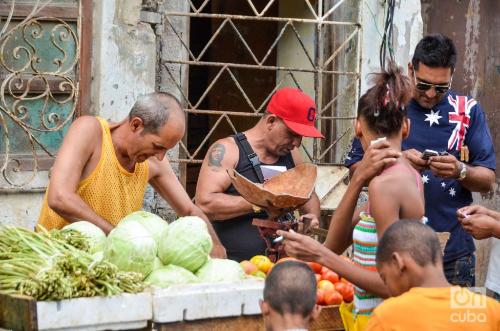 Cubanos compran vegetales en un puesto carretillero, tatuaje del Che, col, habichuelas, economía cubana. Foto: Kaloian.