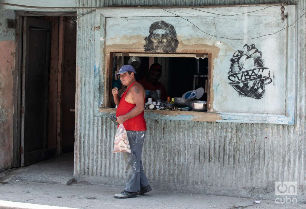 Hombre compra en un establecimiento de comercio minorista en Cuba, pintada del Che, economía Foto: Kaloian.