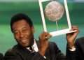 Pelé sostiene su premio FIFA a futbolista del siglo, 11 de diciembre del 2000, en Roma. Foto: Gabriel Bouys/Afp.