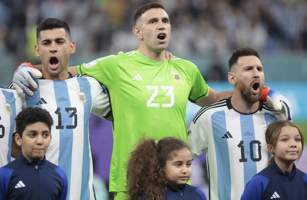 Cristian Romero (i), Emiliano Martínez (c) y Lionel Messi de Argentina cantan el himno antes de comenzar el partido de semifinales frente a Croacia en el estadio de Lusail (Qatar). Foto: EFE/Juan Ignacio Roncoroni.