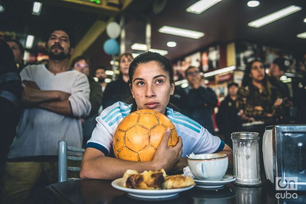 Aficionada argentina mira partido de la selección nacional desde una pizzería porteña. Foto: Kaloian.