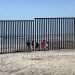 Varios mexicanos miran a través de la cerca en la frontera sur hacia Estados Unidos. |Foto: John Moore/Getty