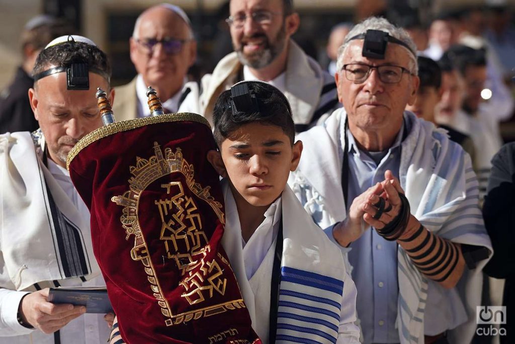 Teenager at his Bar Mitzvah surrounded by other Jews.  Photo: Alejandro Ernesto.