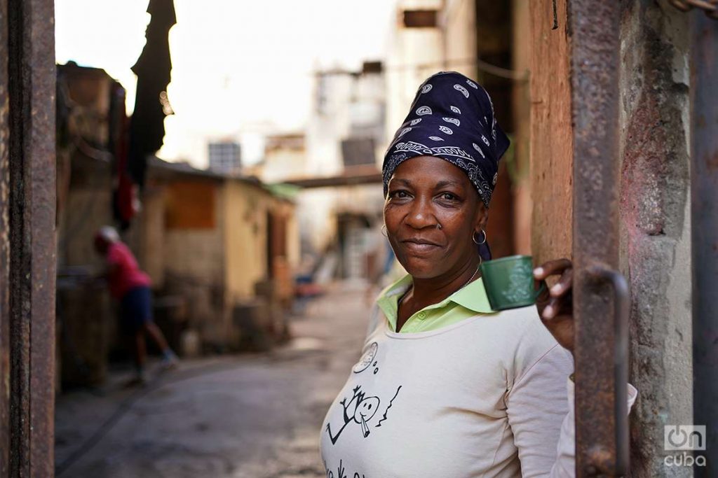 Mujer sonríe y ofrece café en pasillo de La Habana. Foto: Alejandro Ernesto.