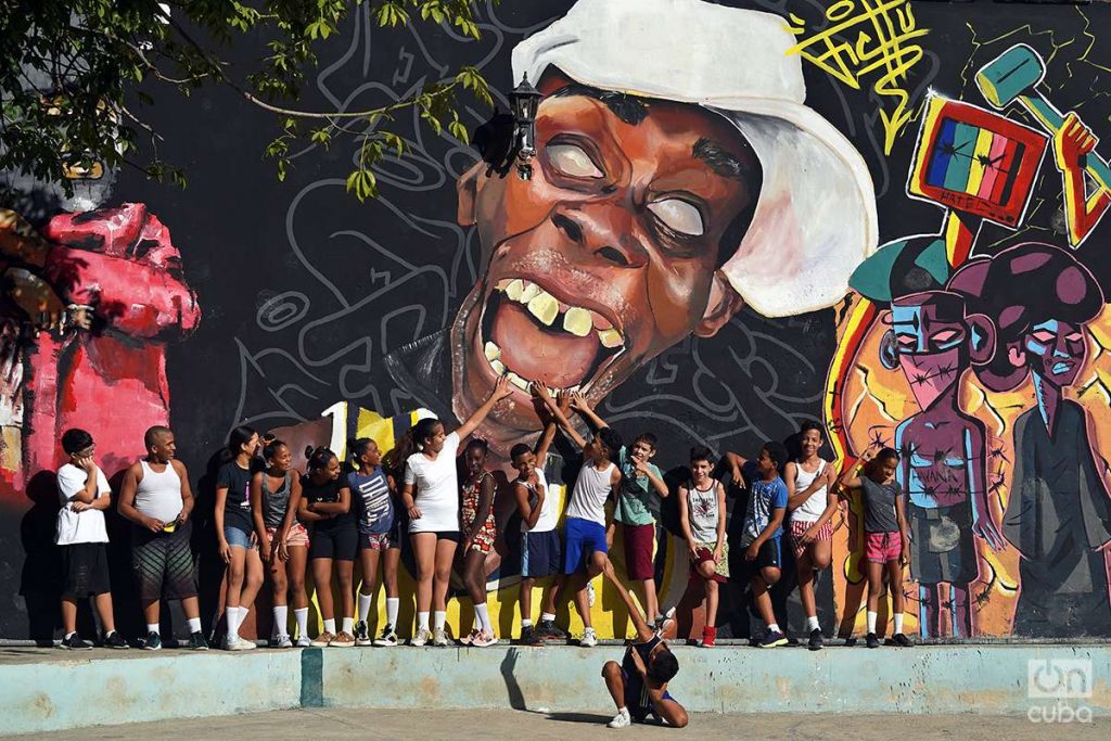 Niños y adolescentes frente a una pintada en La Habana. Foto: Alejandro Ernesto.