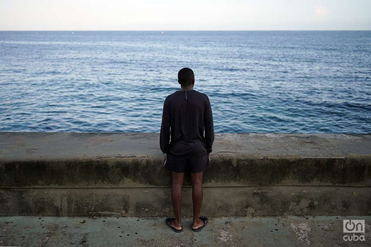 Hombre mira al mar en el muro del malecón de La Habana. Foto: Alejandro Ernesto.