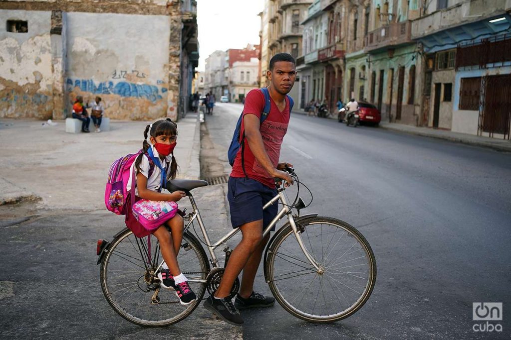 Niña pionera con uniforme en bicicleta en La Habana. Foto: Alejandro Ernesto.