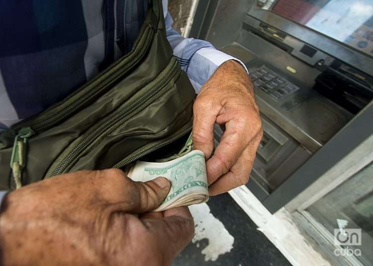 Manos de anciano que extrae pesos cubanos de cajero automático. Dinero 2023. Foto: Otmaro Rodríguez.