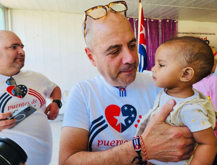 El profesor Carlos Lazo sostiene a uno de los niños ingresados.