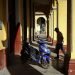 Hombre camina junto a una moto eléctica en un pórtico de La Habana, Cuba, 2023. Foto: Alejandro Ernesto.