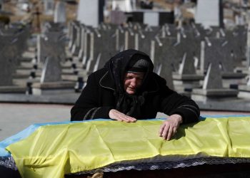 La madre del oficial del ejército ucraniano Ivan Skrypnyk, muerto en acción el 13 de marzo, recostada sobre el ataúd de su hijo durante un funeral en el cementerio militar de Lviv, Ucrania, 17 de marzo de 2022. Foto: EFE/EPA/ATEF SAFADI.