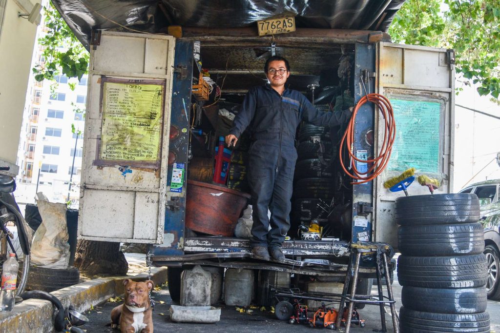 The mechanic in his workshop in front of the kiosk where the plaques dedicated to Mella are.  Photo: Kaloian.