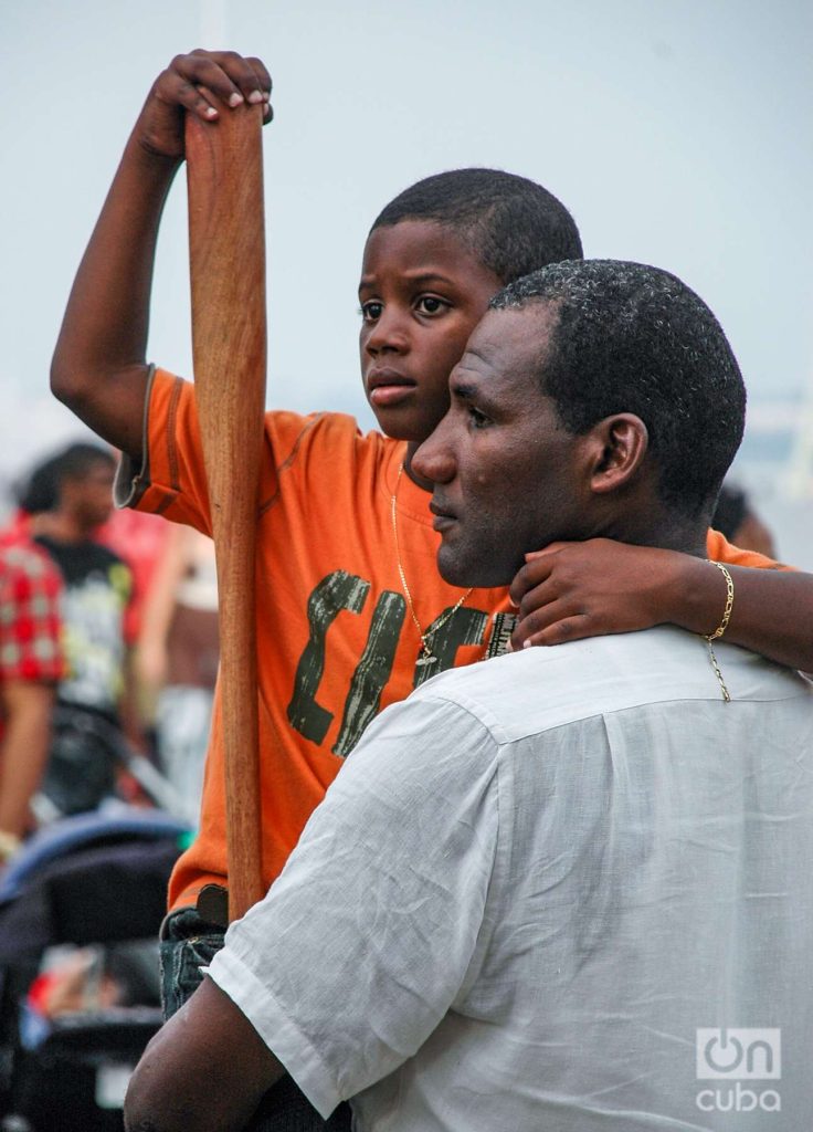 La pasión por la pelota en Cuba se transmite por herencia familiar. Un padre y su hijo con bate de pelota. Foto: Kaloian. 
