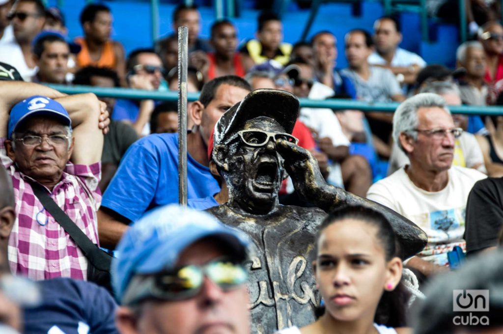 El Latino y la escultura de Armandito el Tintorero, célebre fanático y alentador de la pelota cubana. Foto: Kaloian.
