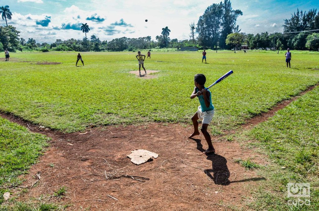 Niños juegan a la pelota en un terreno en las afueras de La Habana. Foto: Kaloian.
