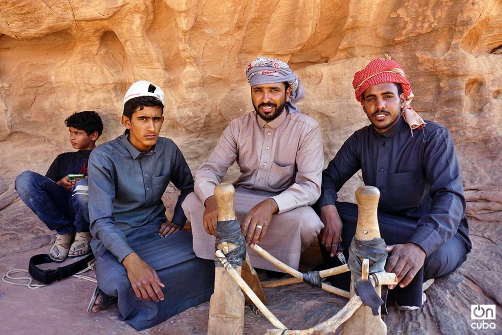 Bedouins pose while handcrafting a saddle for riding a camel.  Photo: Alejandro Ernesto.
