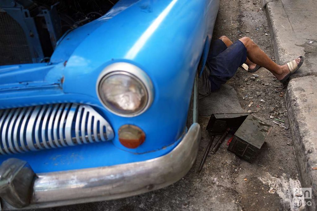 Mecánico repara un almendrón en La Habana 2023. Foto: Alejandro Ernesto.